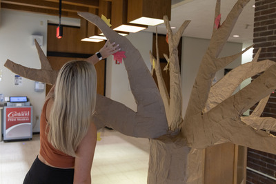 Kara Wolanin hangs a leaf on the gratitude tree